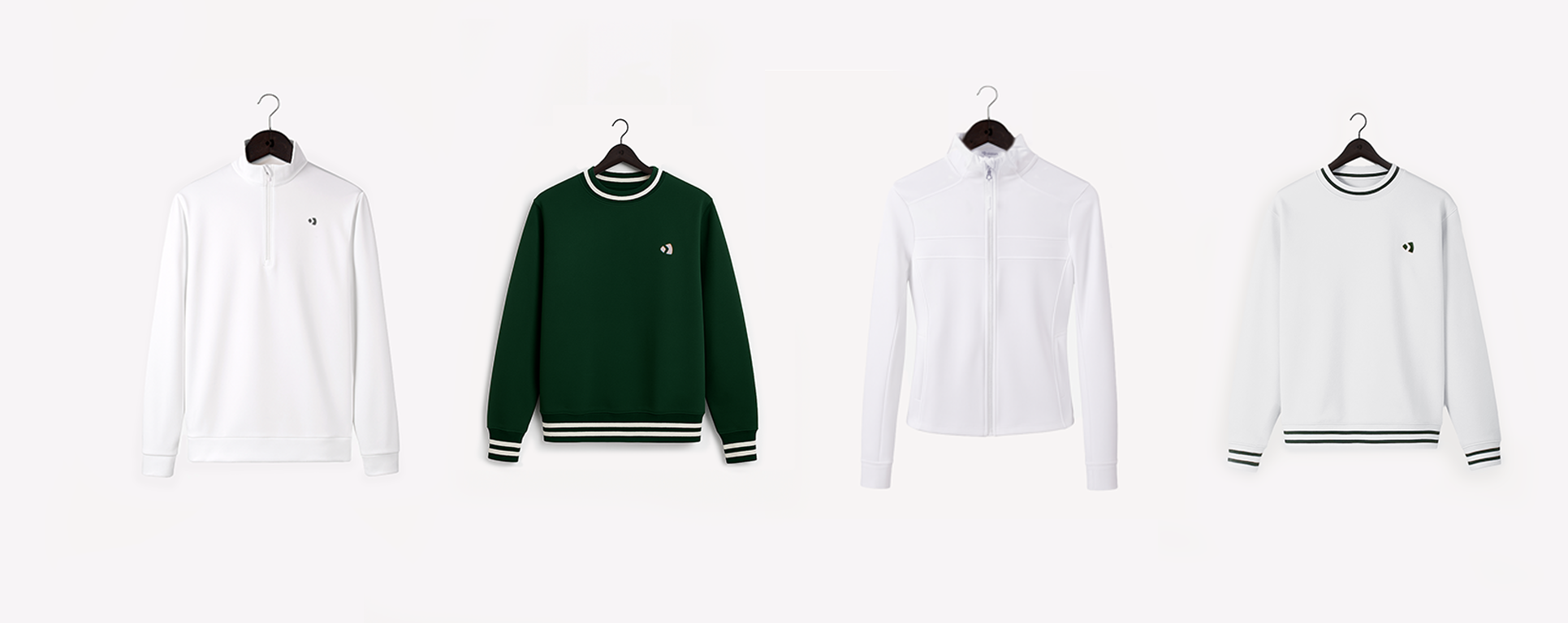 Four Padel jumpers and sweatshirts in white, green, and black on hangers against a white background. Paddle gear all lined up. Padel Tennis clothing. Padel fashion. Studio lighting padel tennis kit. Padel court use. 